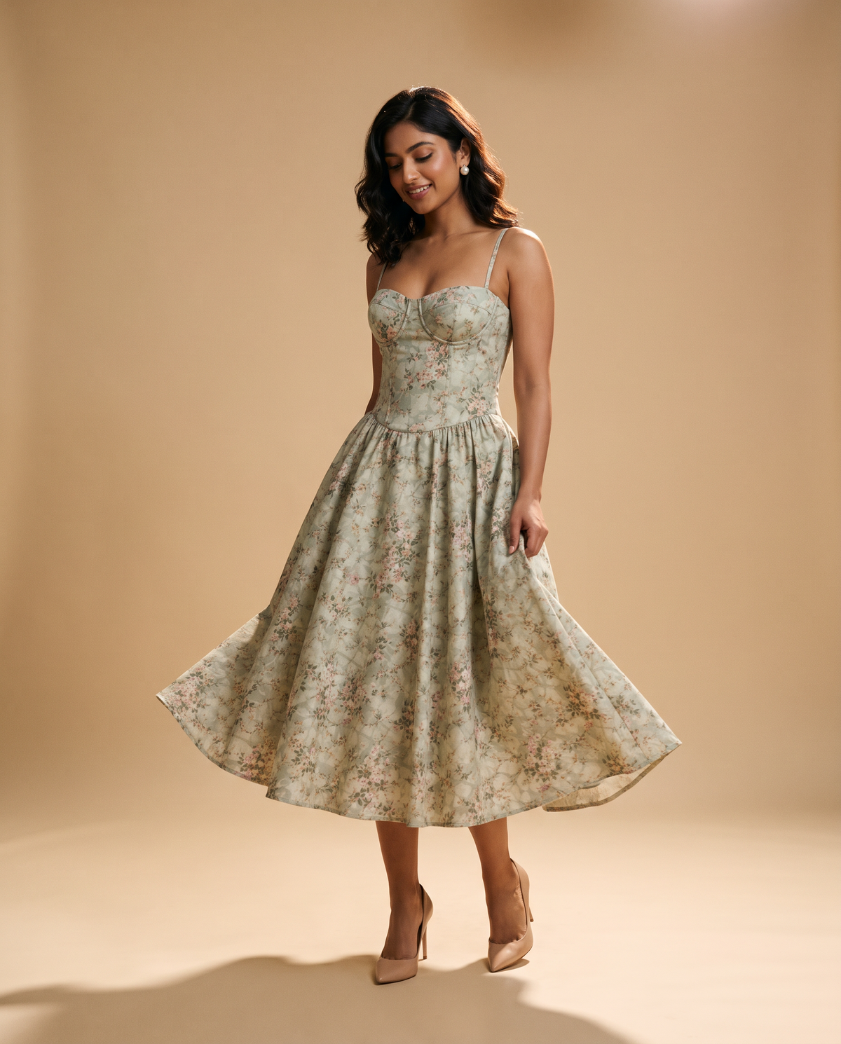 Model mid-turn in the sage floral corset midi dress on a warm sand studio backdrop